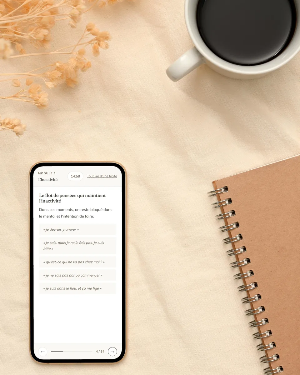 Une page de module Aria ouverte sur un téléphone, posé à côté d’un carnet et d’une tasse de café