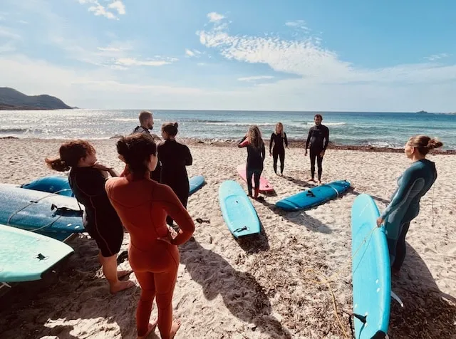 Un groupe sur la plage de Capo di Feno, planches de surf posées sur le sable
